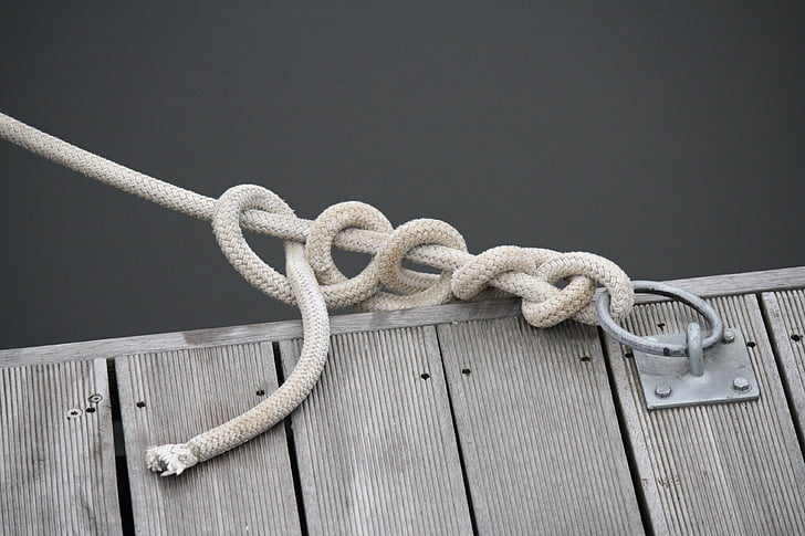 close up photo of white rope tie on buckle