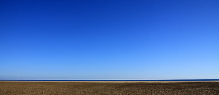desert field with ocean during daytime