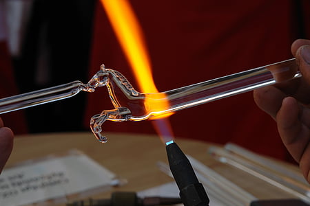 shallow focus photography of glass blower making glass horse