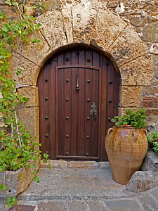 brown wooden door beside round brown pot plant
