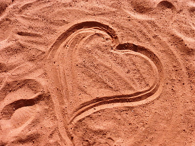 heart drawing on brown sand