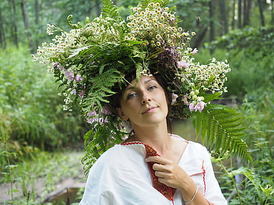 selective focus photography of woman wearing leaves and flowers hat