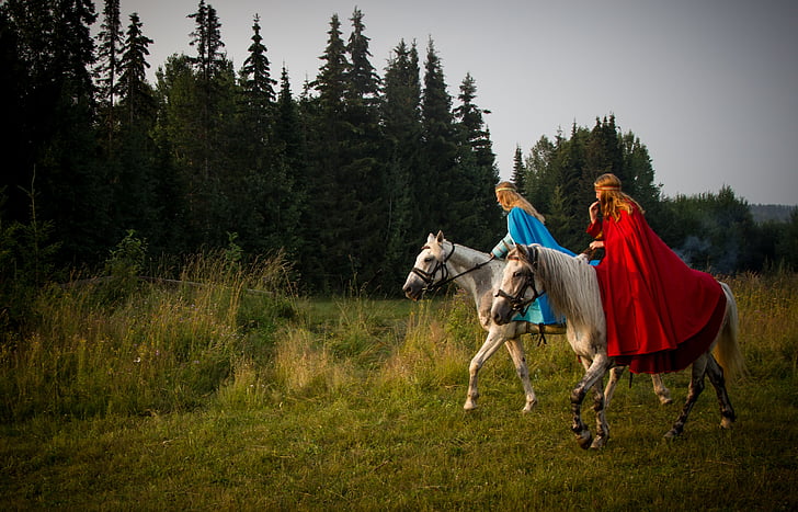 two women riding white horses