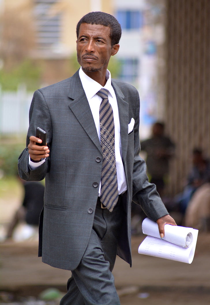person wearing gray blazer holding white printer paper