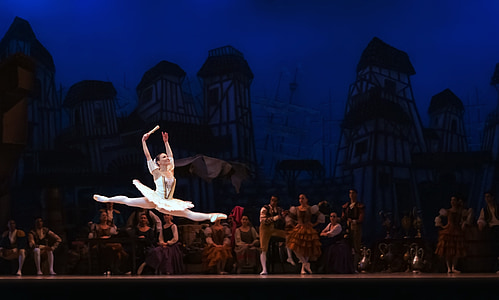 photography of ballet dancer jumping on stage