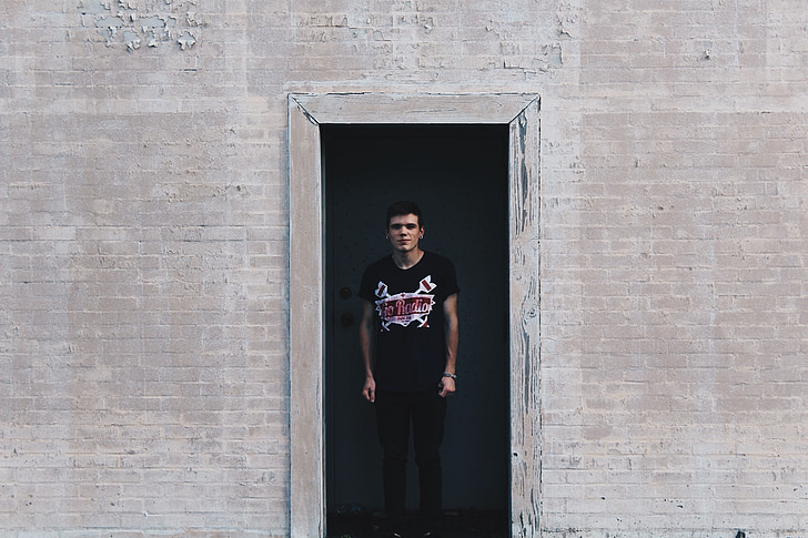 man in black shirt standing on doorway