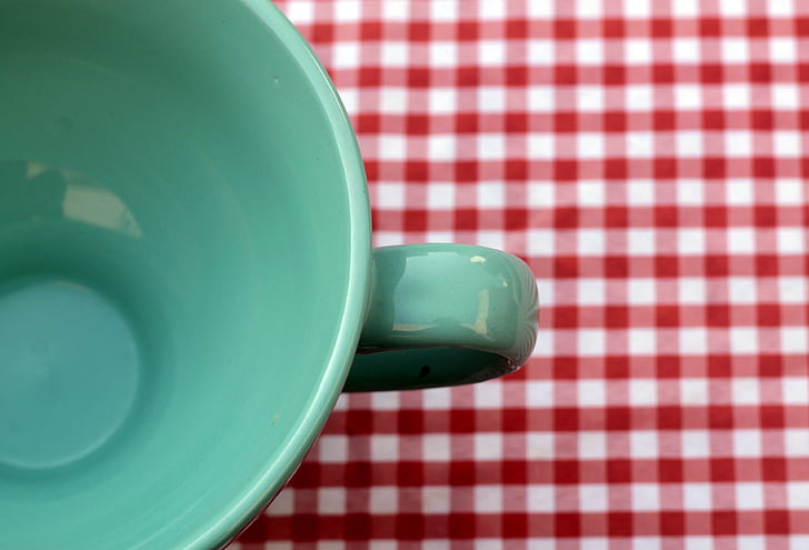 green cup on white and red gingham mat