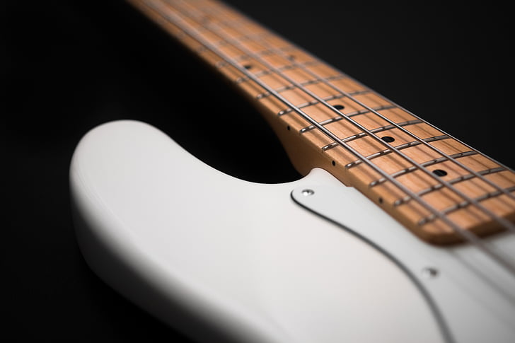 closeup photography of white and brown 4-string bass guitar