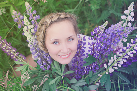 woman beside purple-and-white flowers