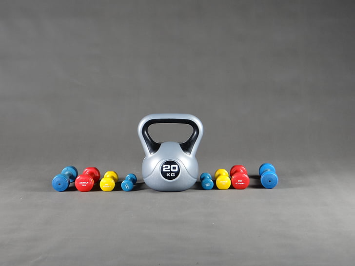 gray kettle bell and fixed weight dumbbells