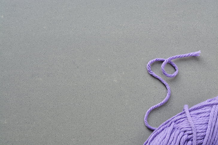purple rolled yarn on table