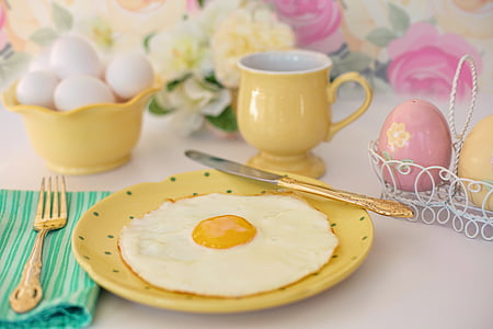 yellow ceramic mug near round yellow plate with fried egg on top