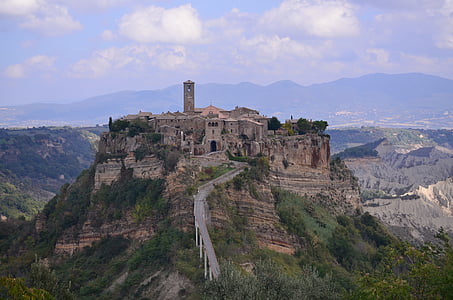 high angle photo of castle surrounded by mountain range