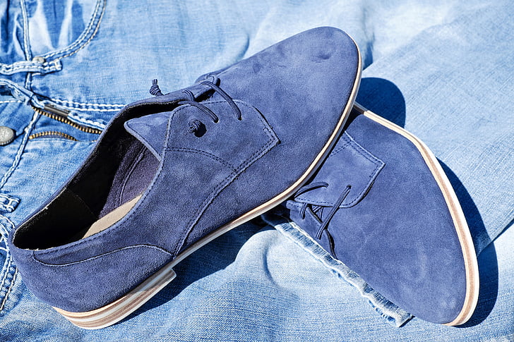 pair of blue suede chukka shoes on blue denim shorts -