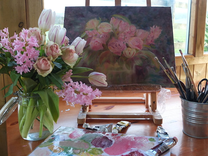 flowers on vase beside painting