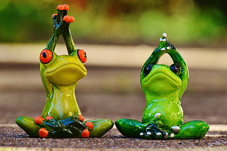 selective focus photography of two green ceramic frogs yoga post figurines