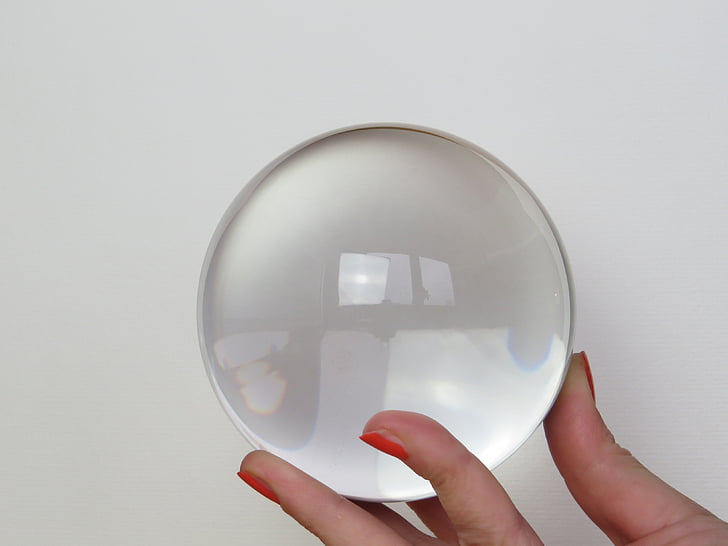 person holding a clear glass ball