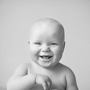 grayscale photography of smiling topless baby