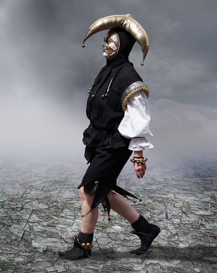 person wearing black, white, and gold jester suit