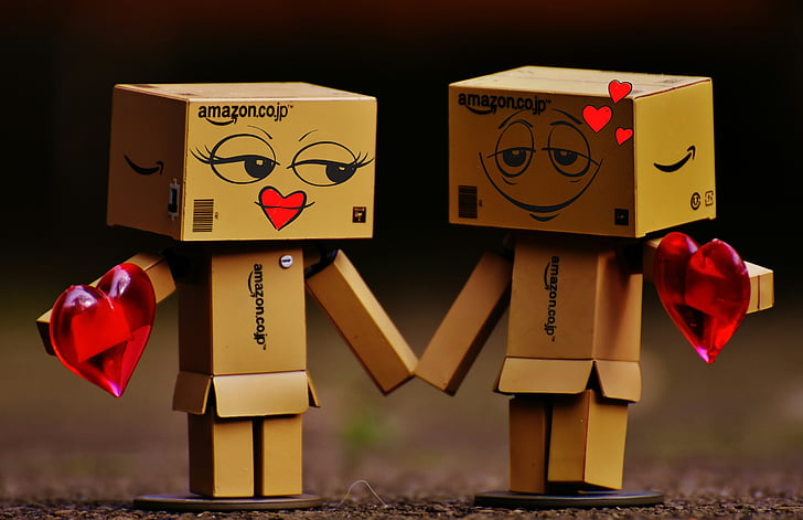 Royalty-Free photo: Two Amazon box robots holding hands |