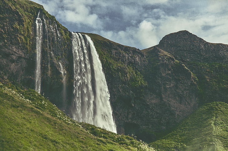 waterfalls on the mountain during daytime