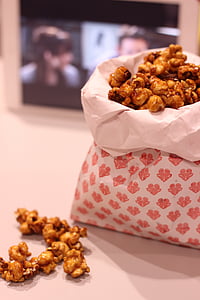 caramelized popcorn on desk near flat screen monitor