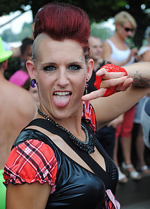 close-up photography of woman doing rock and roll hand posture with tongue out outdoors