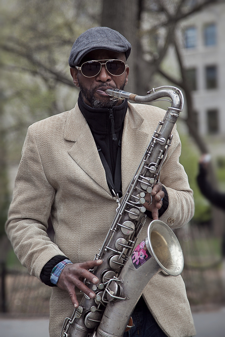 man in brown suit playing gray saxophone