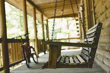 shallow focus photography of brown wooden swing bench