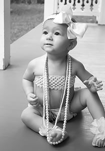 grayscale picture of baby sitting on the floor