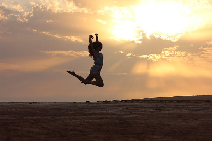 woman jumping during sunset