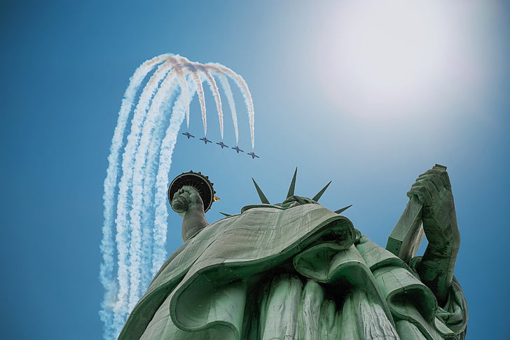 Statue of Liberty in low-angle photography of five airplanes
