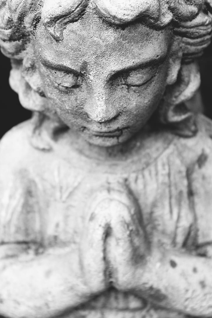 closeup photo of girl praying concrete statue