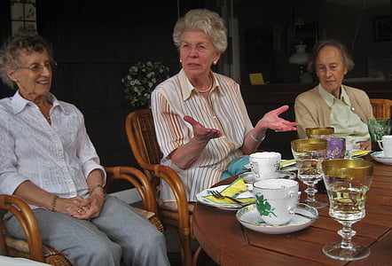 three dressed woman sitting near table