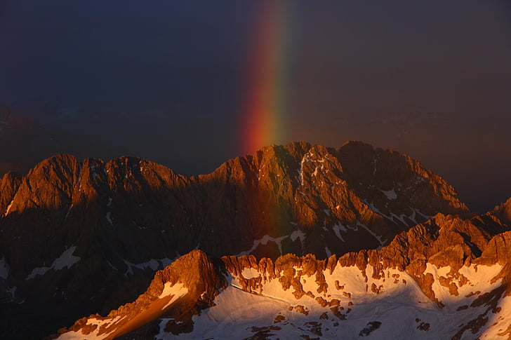 landscape photography of rainbow near rock formation