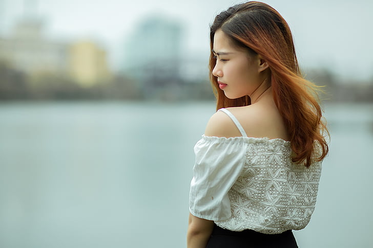 shallow focus photography of woman in white cold shoulder top