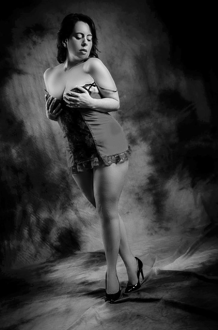 grayscale photo of woman standing posing holding her breast