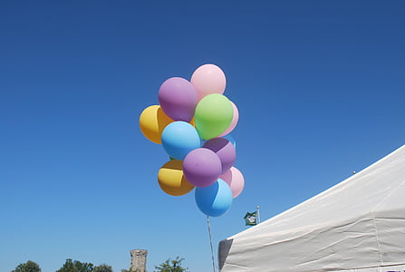 assorted-color balloon beside white tent during daytime