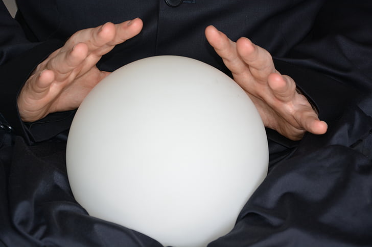 person holding round frosted glass ball