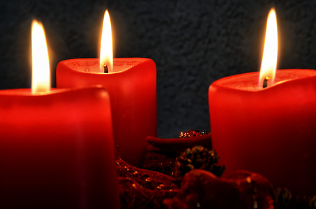 closeup photo of three lighted red candles