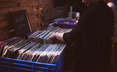 man looking at vinyl cases on the crate