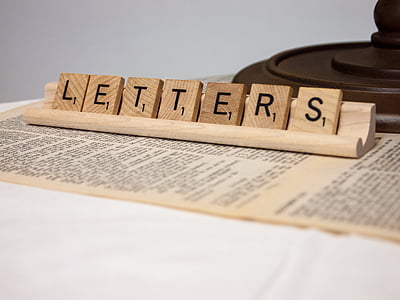 brown wooden scrabble tiles displaying letters