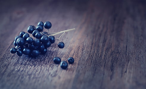 blueberries placed on brown wooden surface