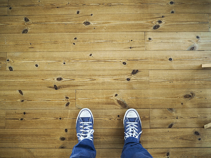 high angle photo of person wearing pair of blue sneakers