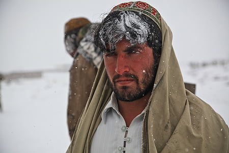 man wearing brown shawl with snow on his hair