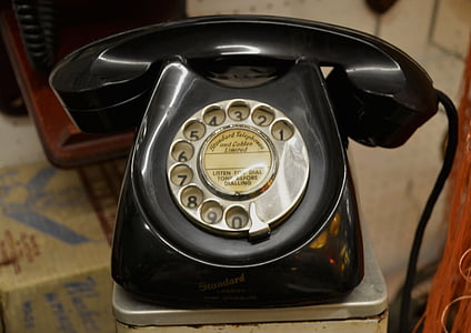 black rotary phone in gray metal surface