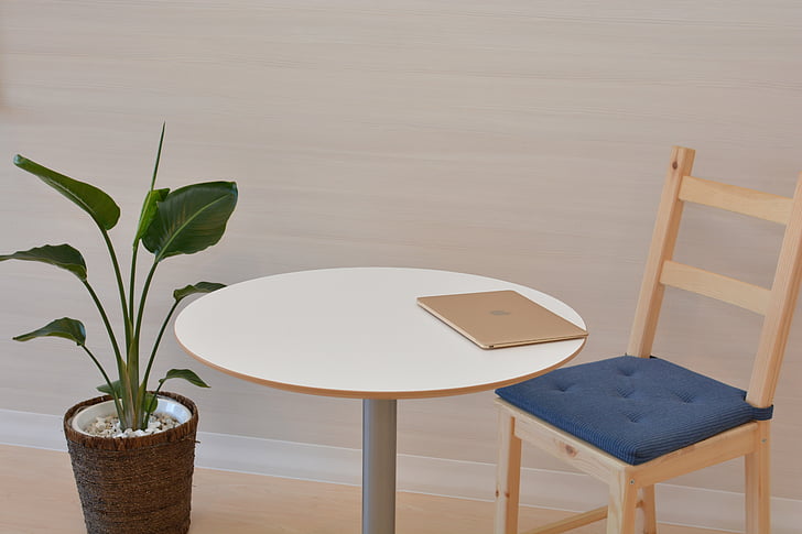 round brown wooden table beside plant
