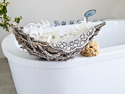 white steel bathtub beside gray stump and brown sponge