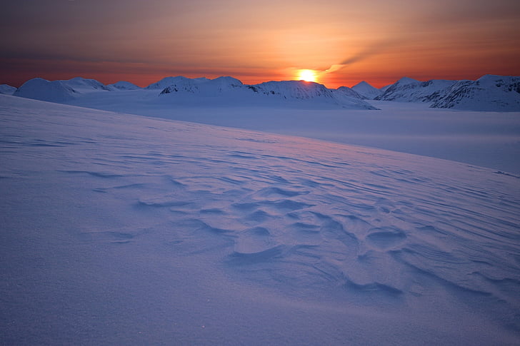 mountain covered with snow at sunset