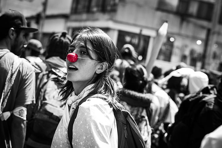 selective photography of woman wearing red nose cover